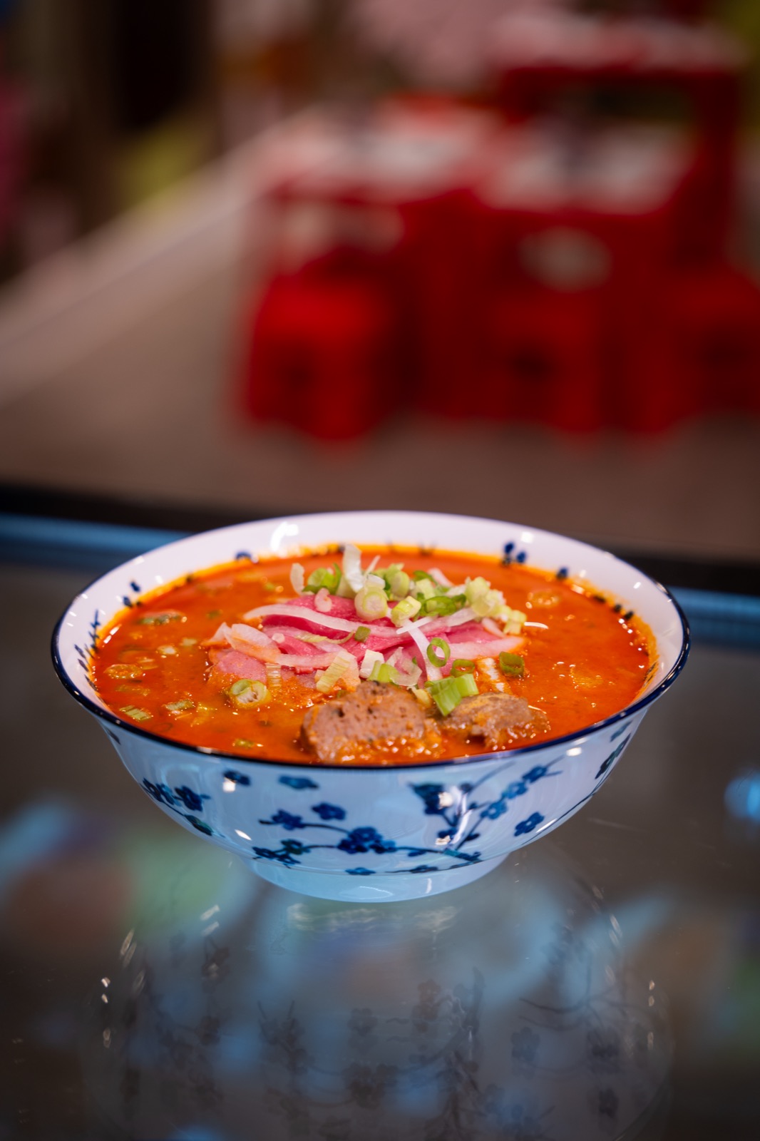 A vibrant bowl of Chào Mámì Express satay pho with beef, scallions and pickled onion